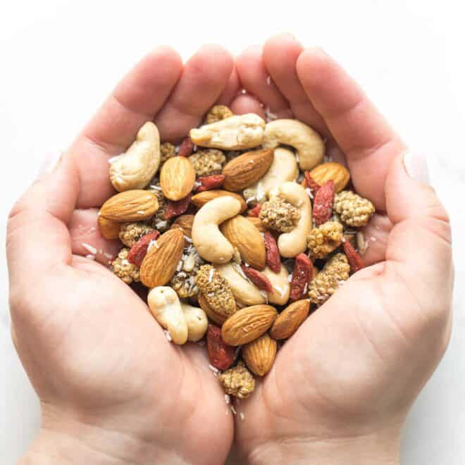 two hands holding a snack mix