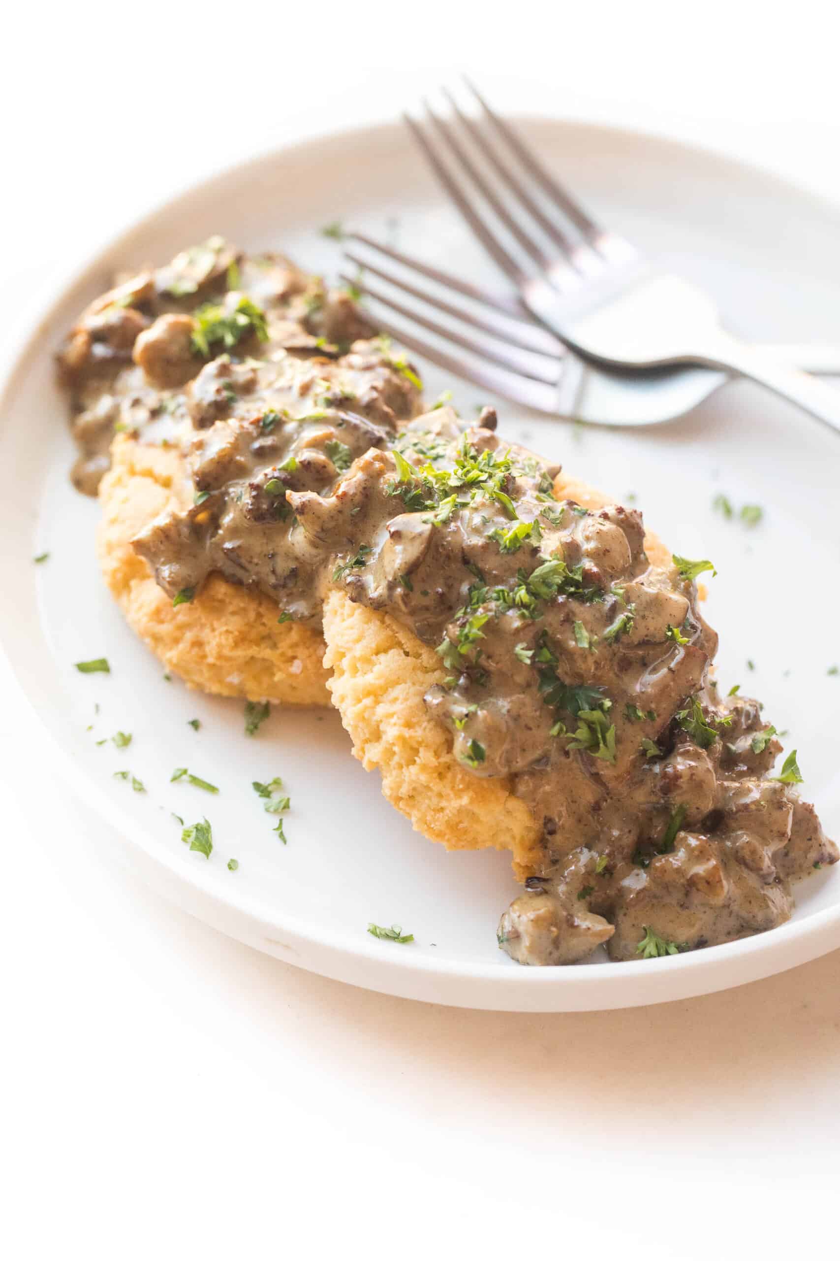 KETO BISCUITS AND GRAVY ON A WHITE PLATE