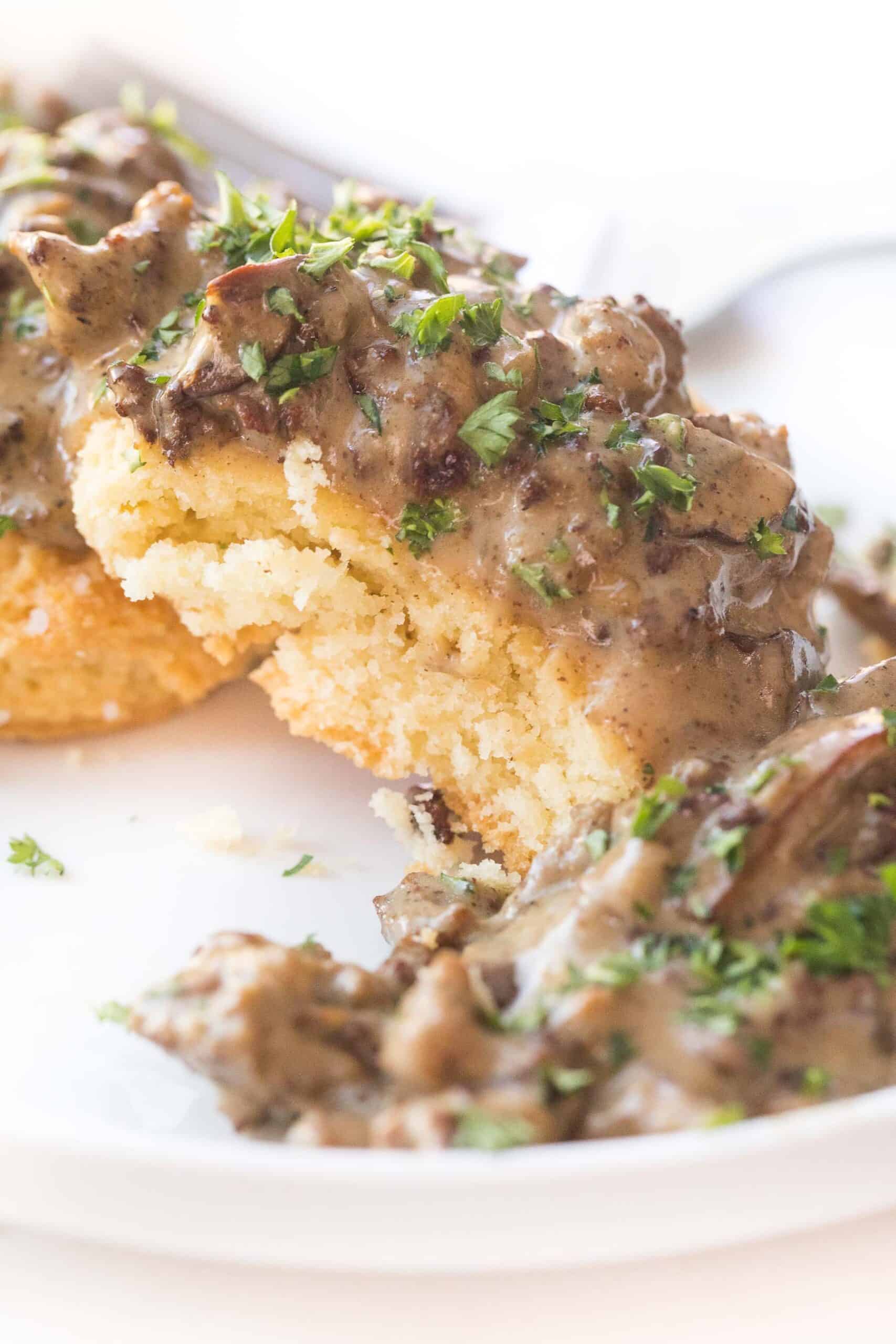 KETO BISCUITS AND GRAVY ON A WHITE PLATE