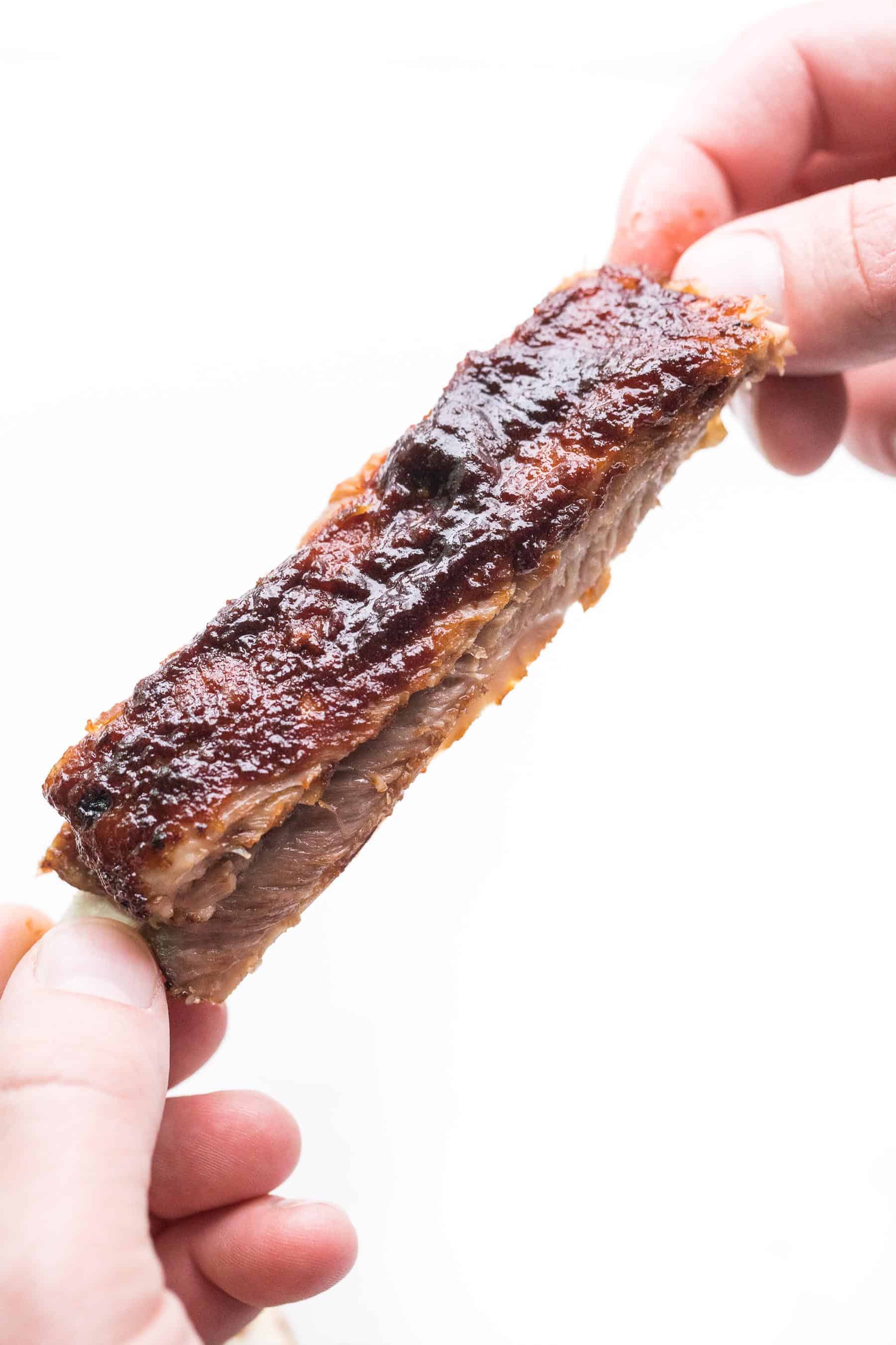 2 hands holding a bbq rib