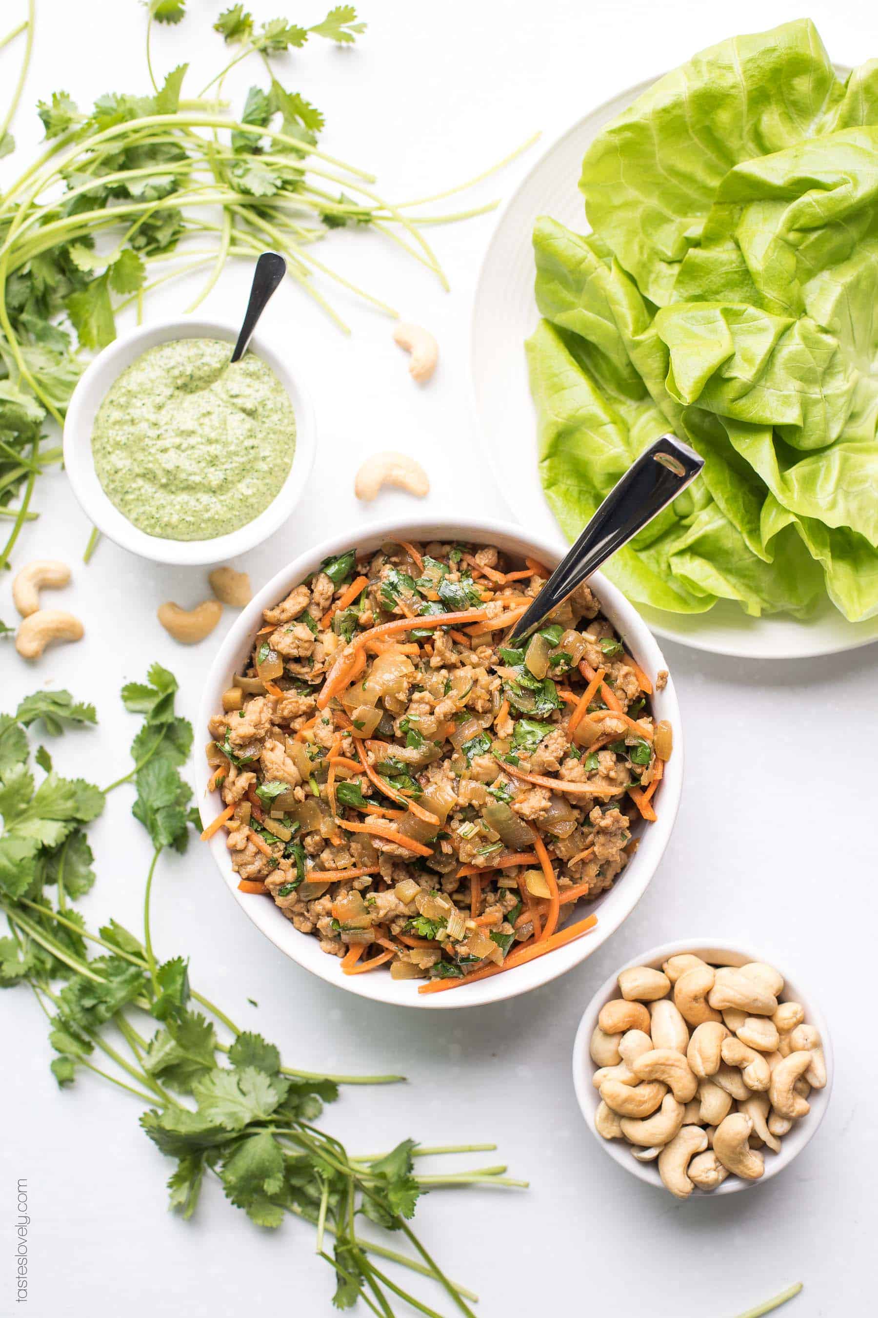 Paleo + Whole30 Thai Chicken Lettuce Wraps - a quick and healthy dinner recipe with ground chicken, sauteed onions, a thai sauce, cilantro and shredded carrots. Topped with a bright and fresh herby green dressing and cashews. #paleo #whole30 #glutenfree #grainfree #dairyfree #sugarfree #keto #cleaneating #realfood