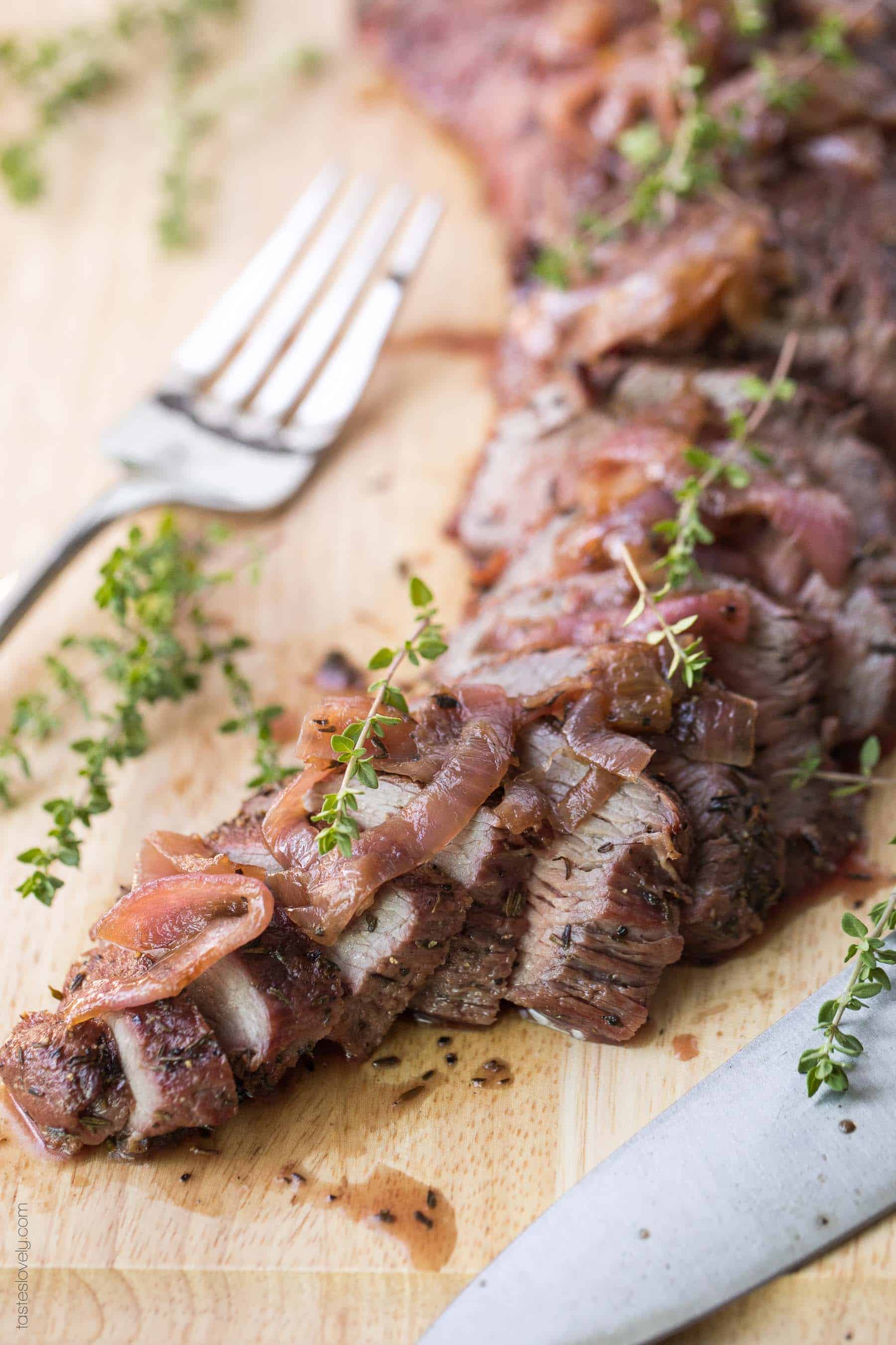 an up close shot of steak topped with grilled onions