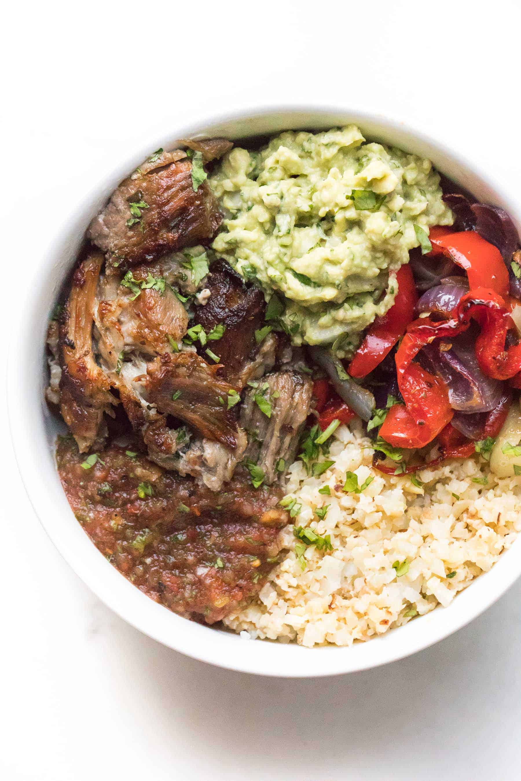 carnitas burrito bowl in a white plate on a white background