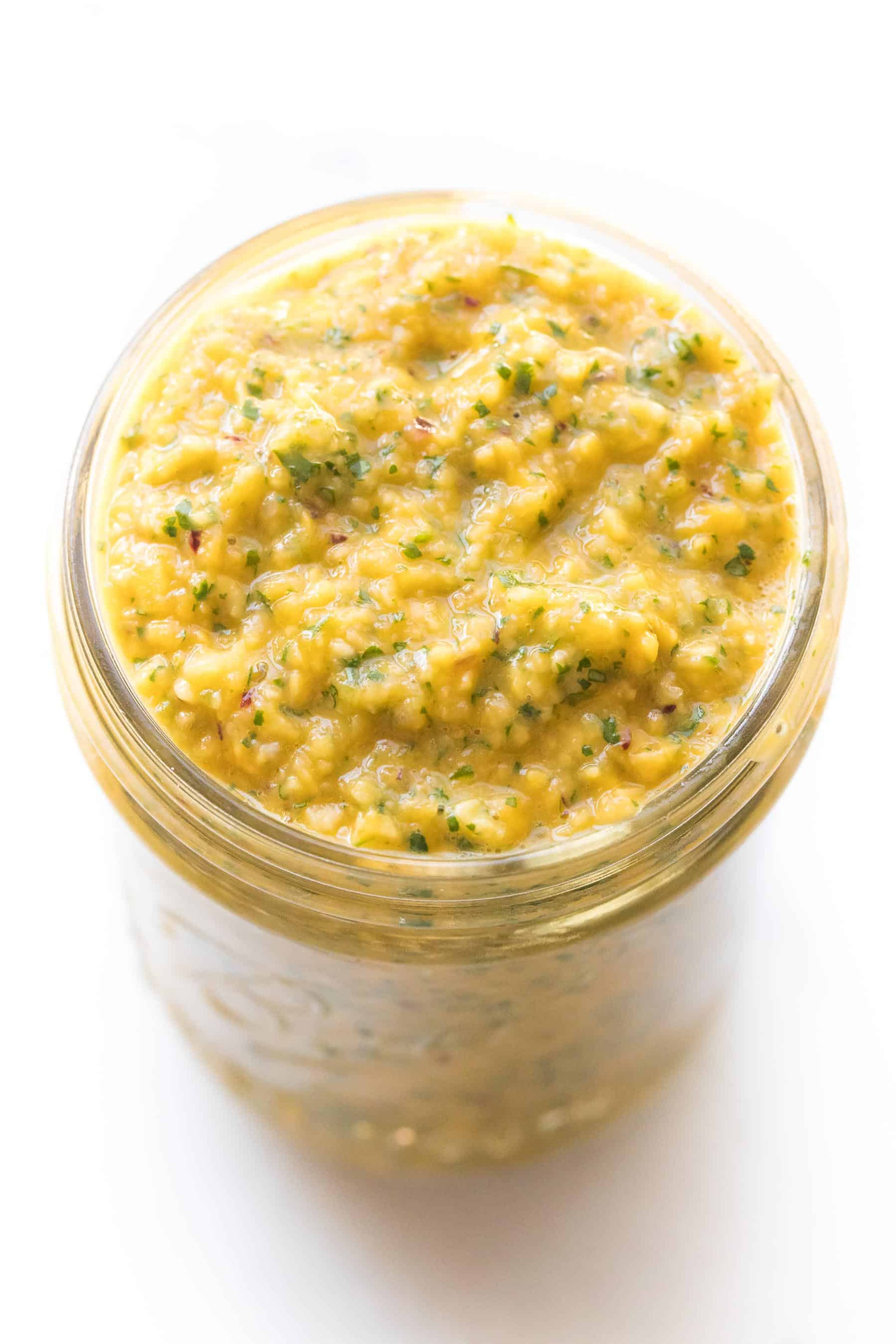 mango salsa in a mason jar on a white background