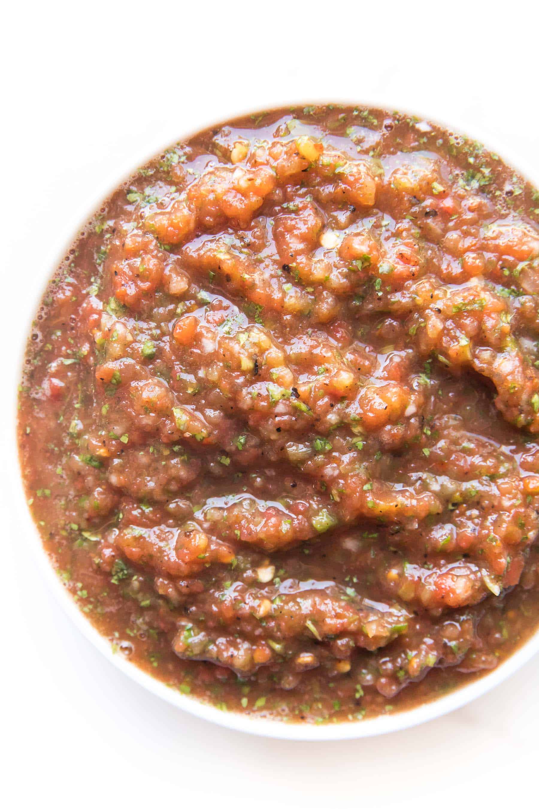 homemade red salsa in a white bowl on a white background