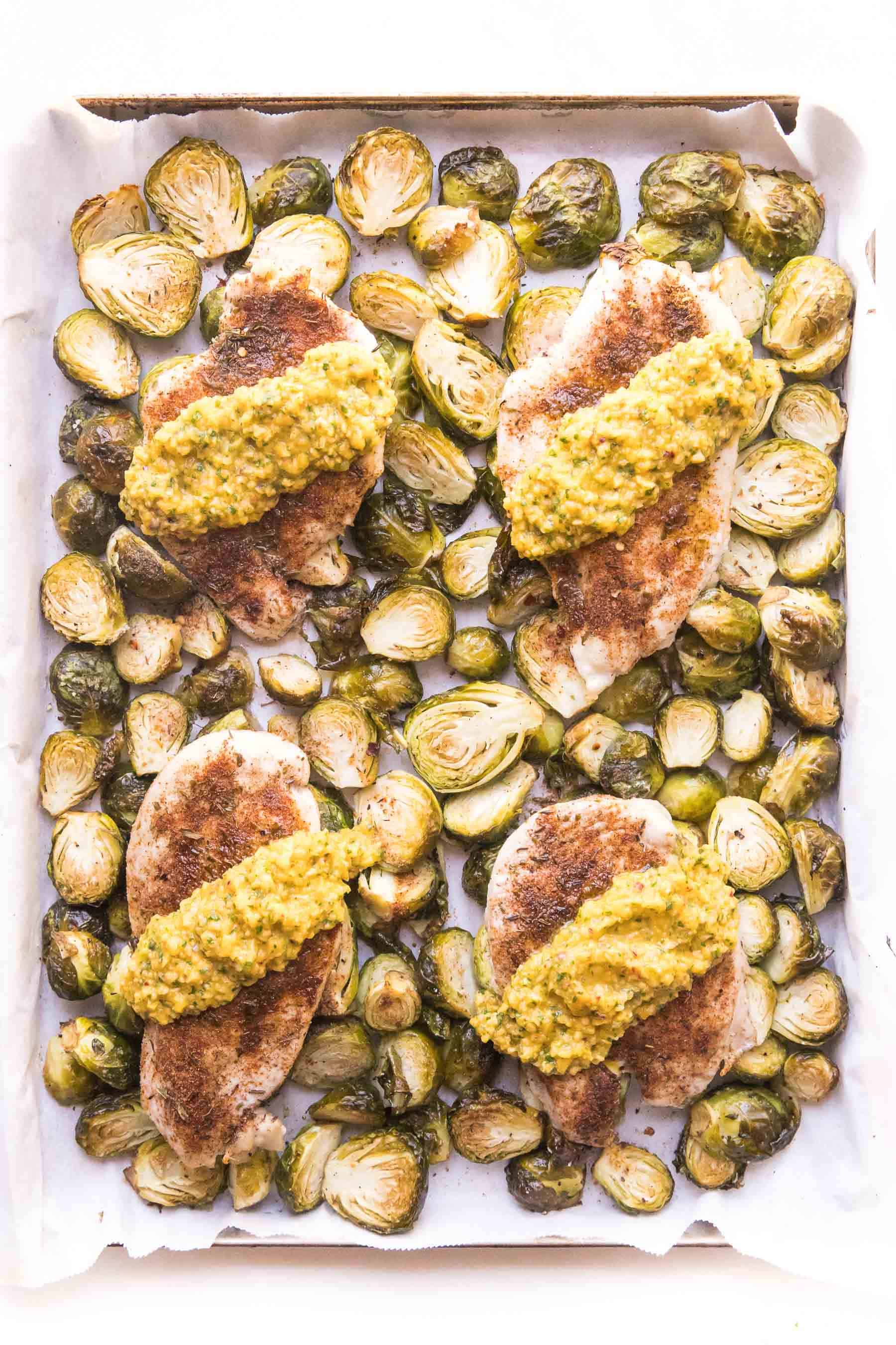 sheet pan brussels sprouts and chicken topped with mango salsa