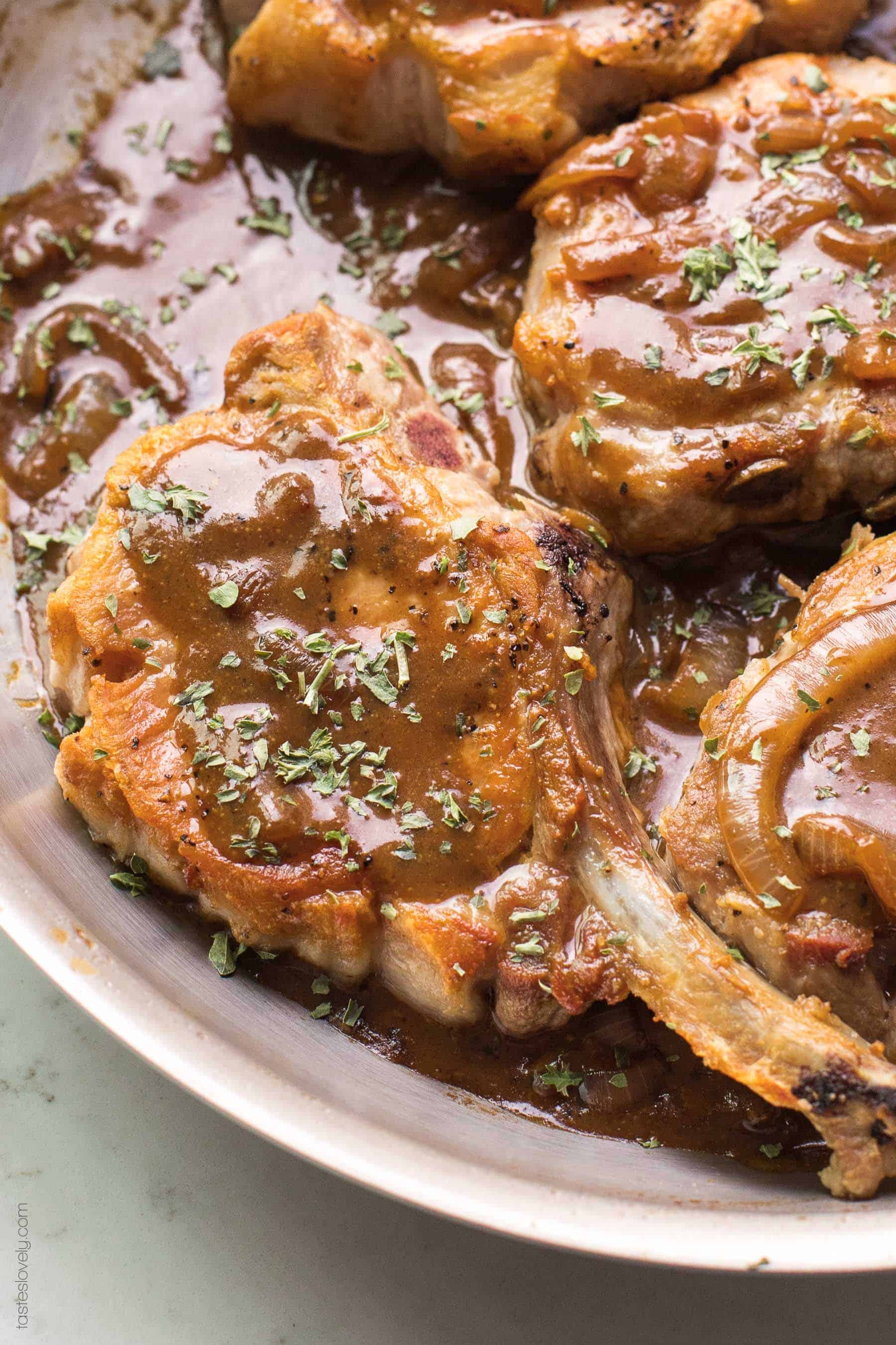 Pork chops in a brown sauce in a skillet