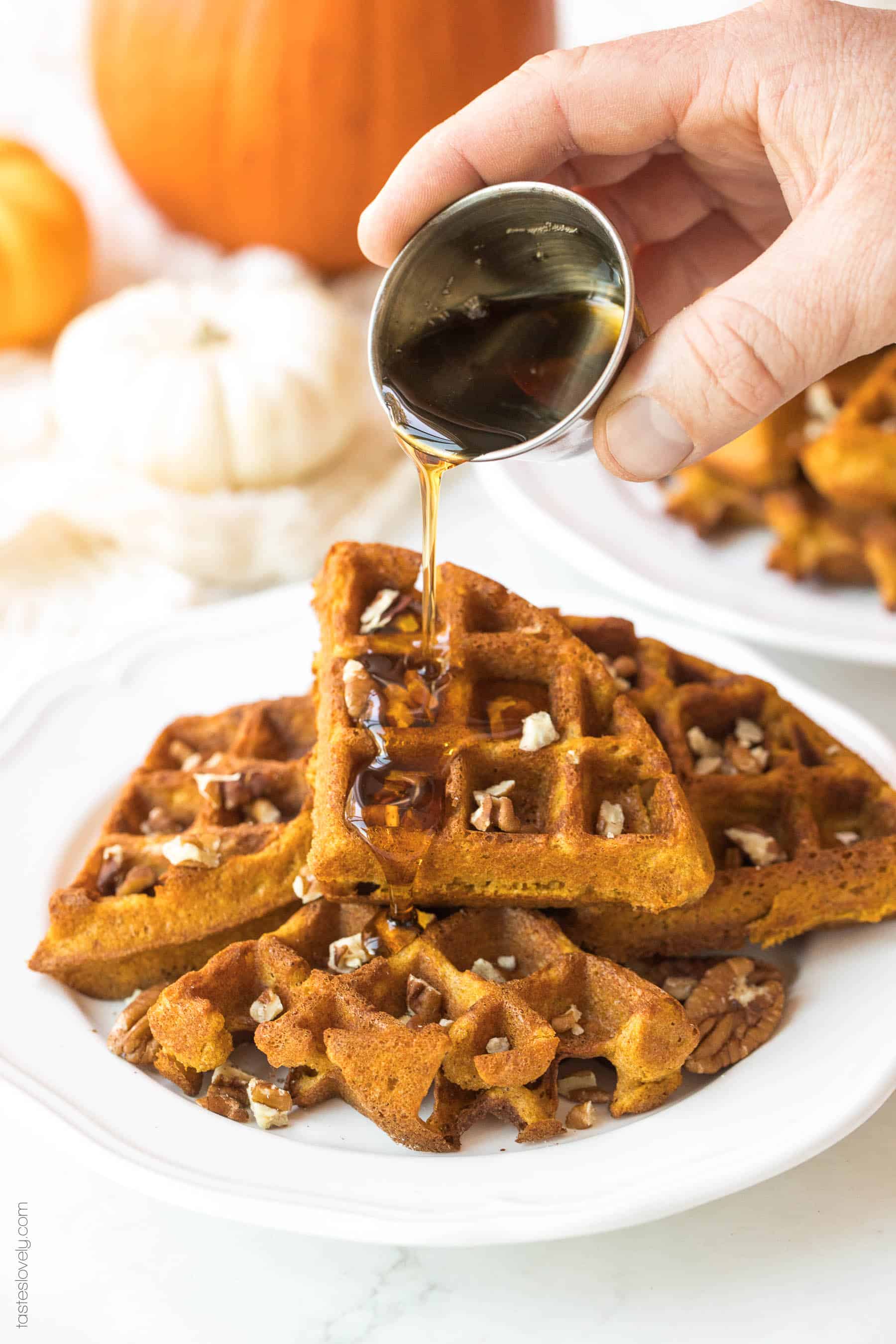 syrup being poured on top of pumpkin waffles