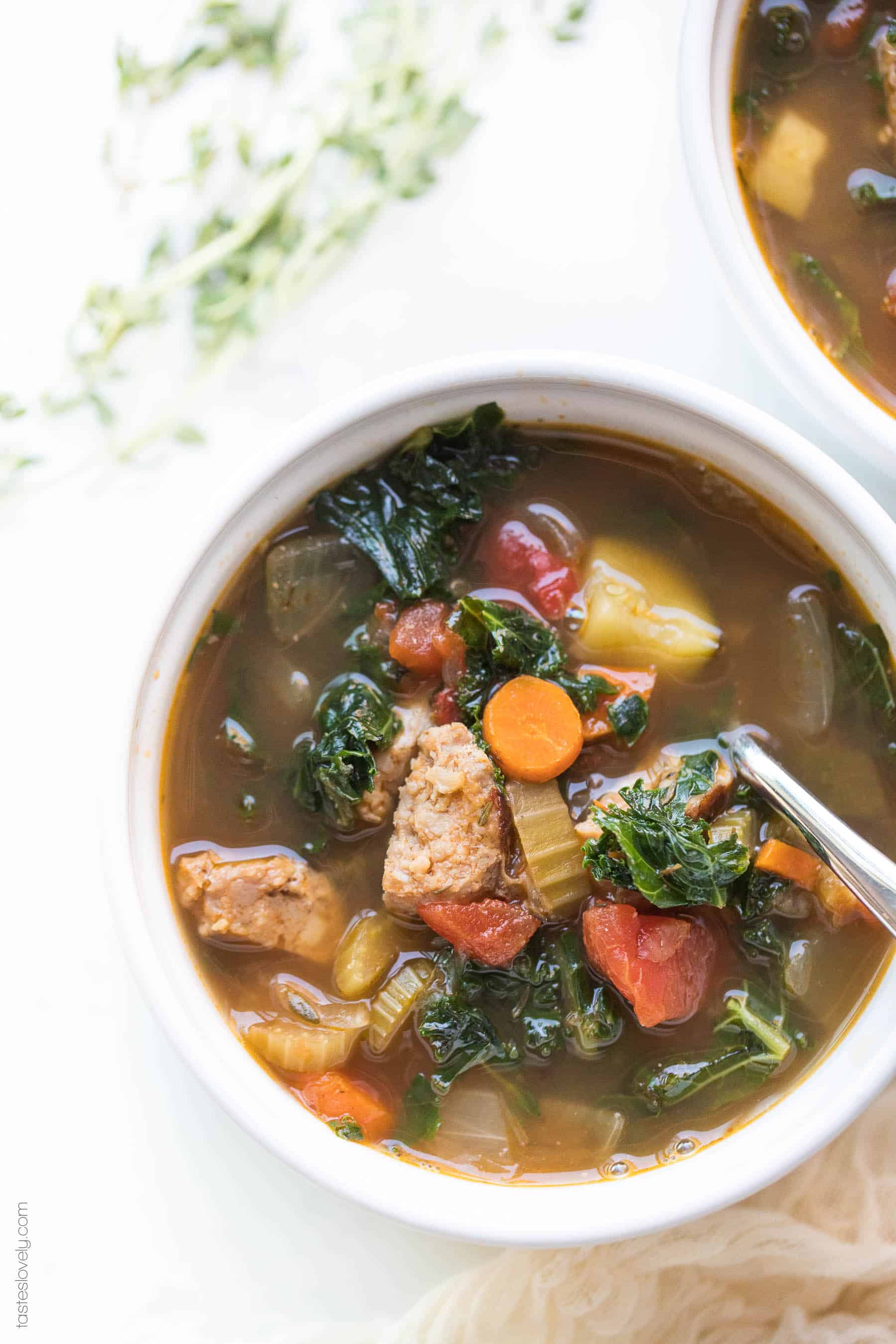 A bowl of sausage and kale vegetable soup
