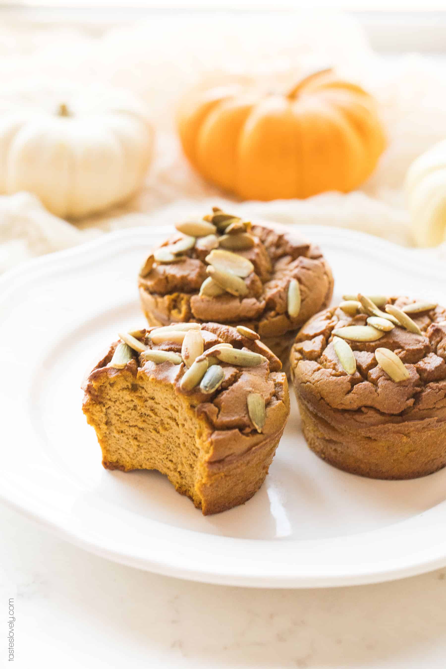 a plate of paleo pumpkin muffins, 1 has a bite taken out of it