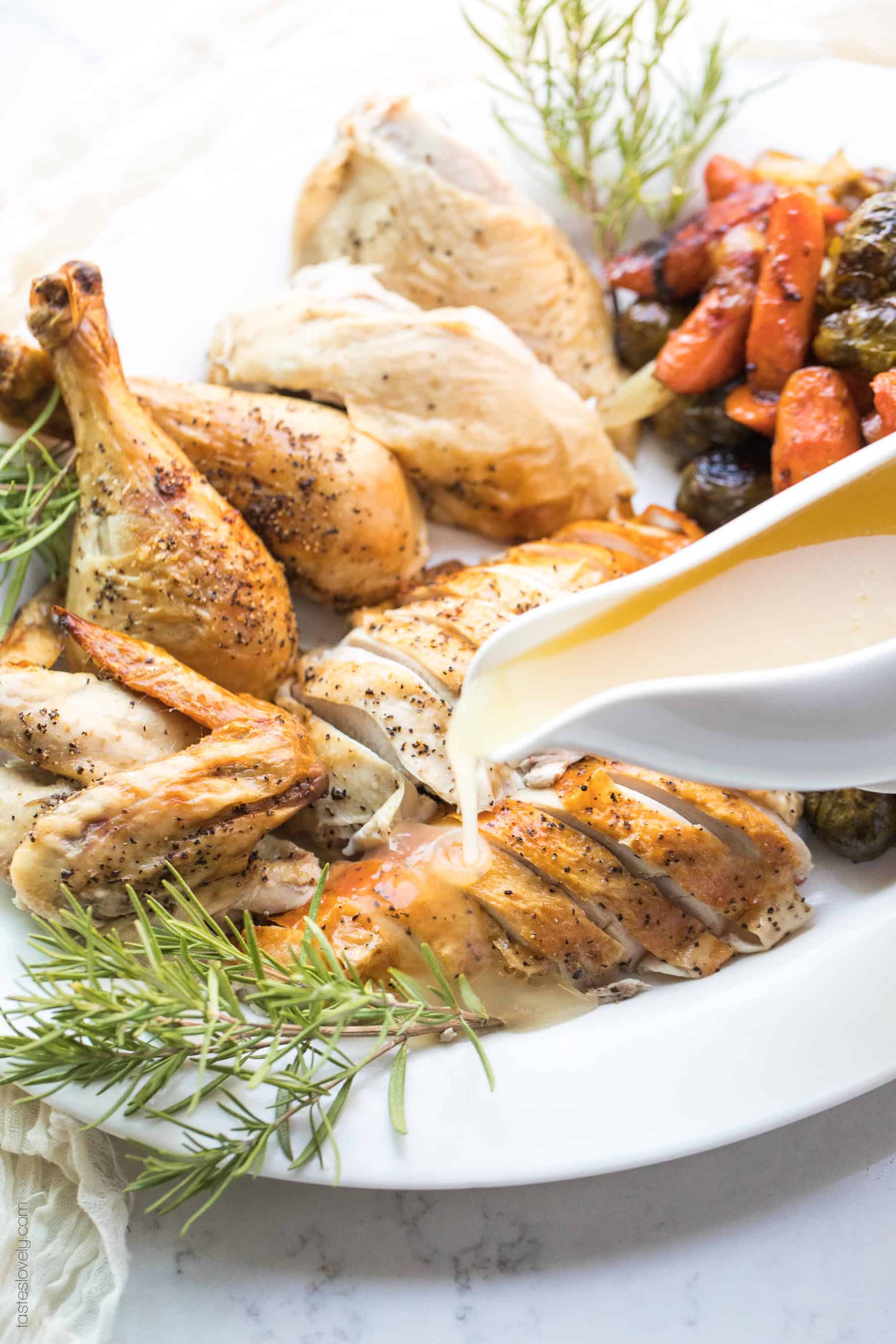 Gravy being poured over sliced roasted chicken breasts