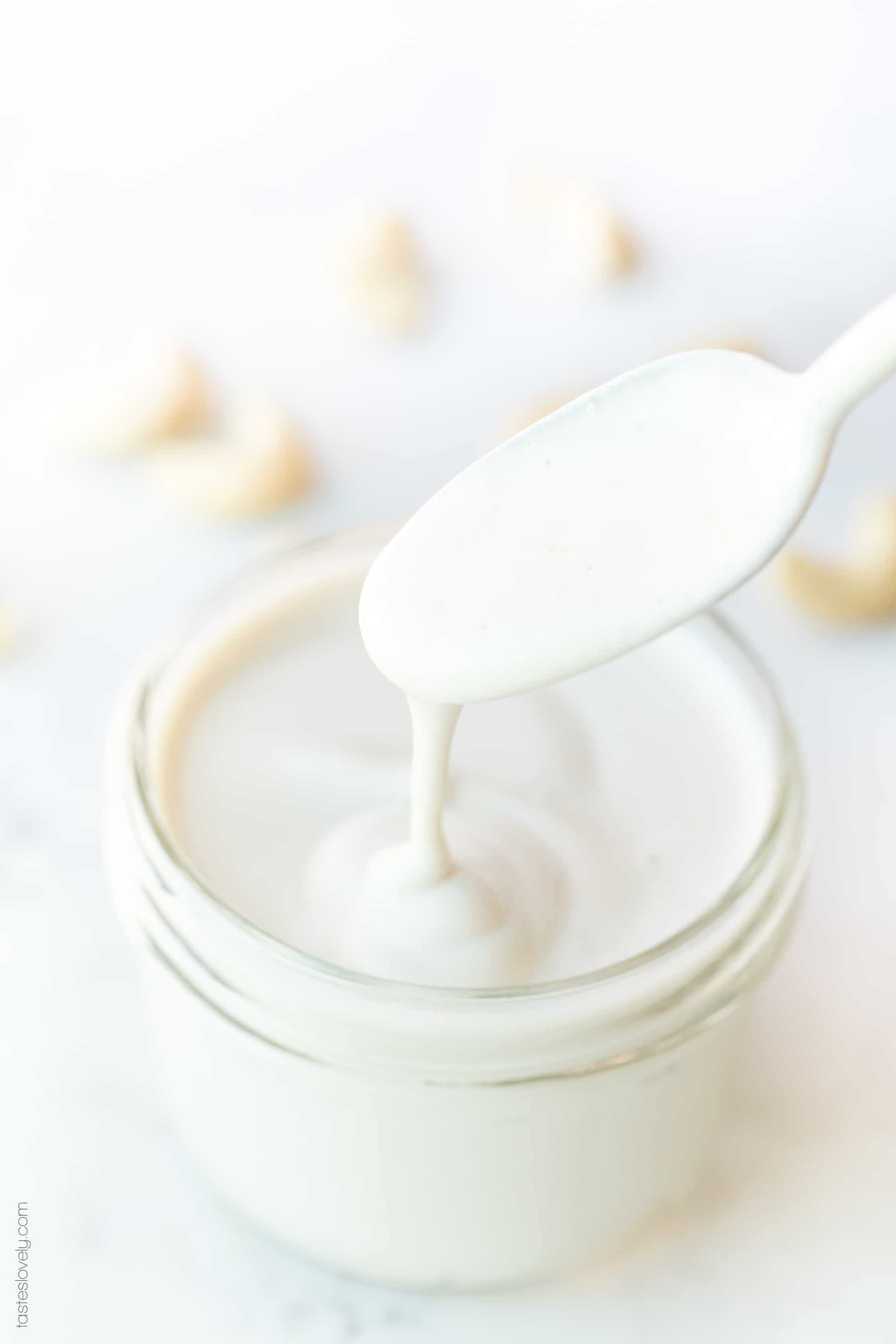 A spoon drizzling cashew cream in a jar