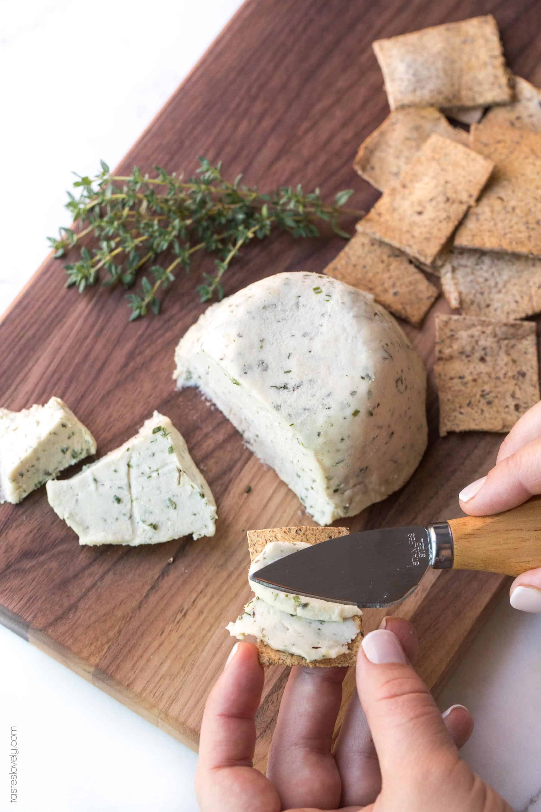 Cheese on a board sliced with crackers and herbs