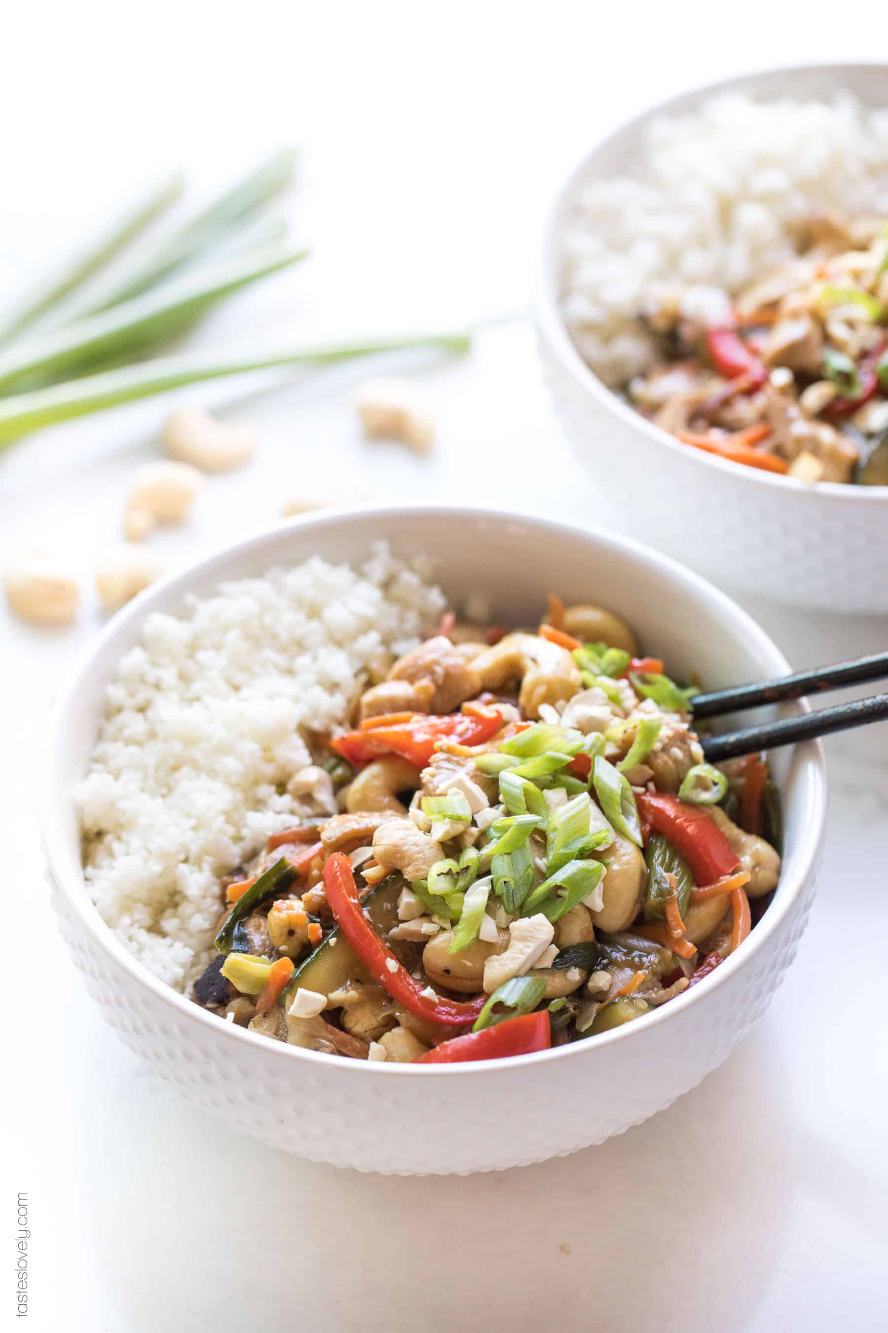 a white bowl with chicken stir fry, cauliflower rice and chopsticks