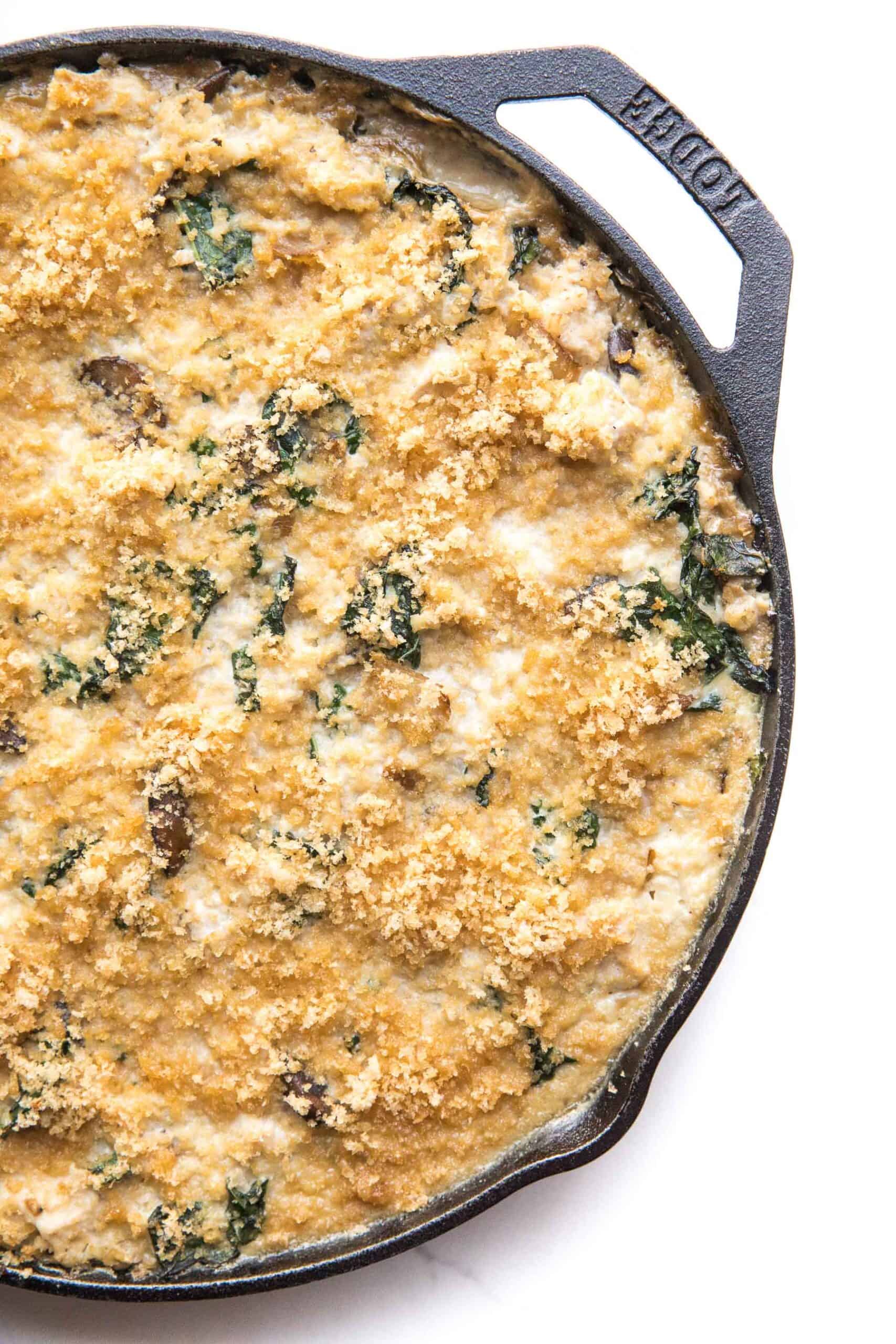 creamy chicken caulifloer rice casserole in a cast iron skillet