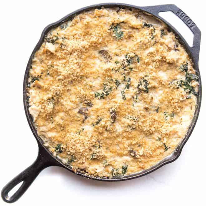 a cast iron pan with creamy chicken and cauliflower rice 