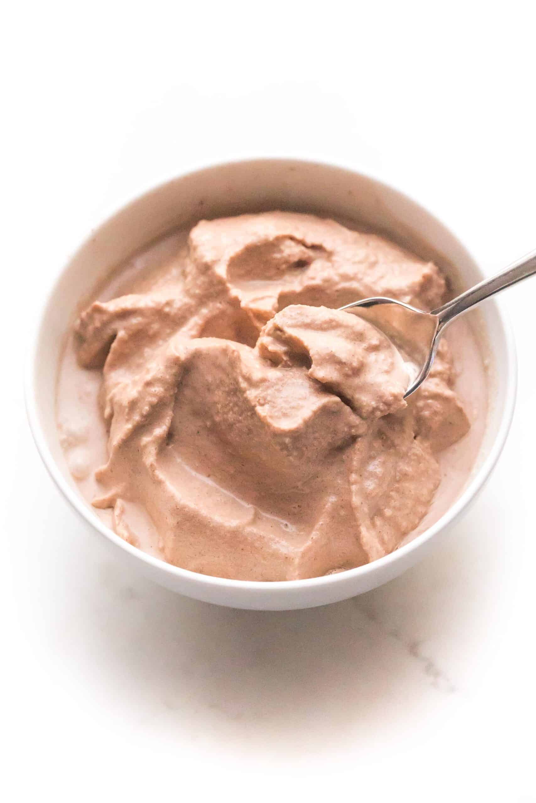 spoon in a chocolate frosty in a white bowl and background