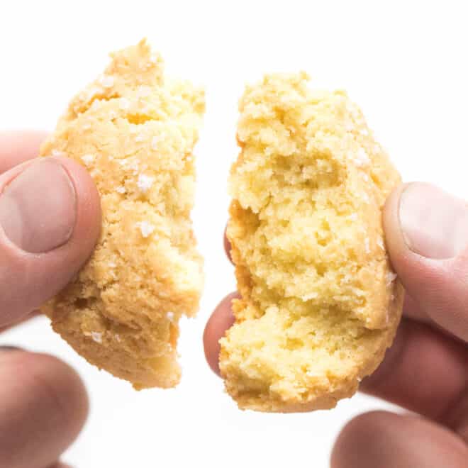a hand breaking apart a keto biscuit