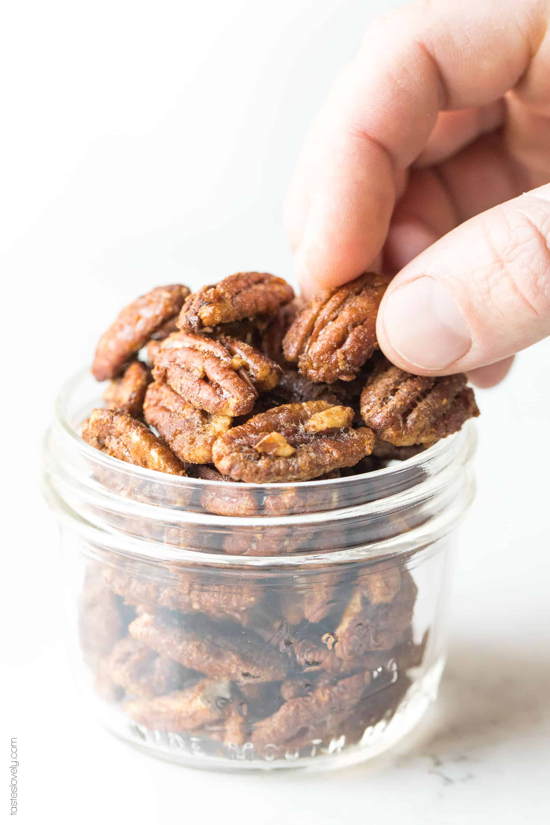 Hand picking up a candied pecan