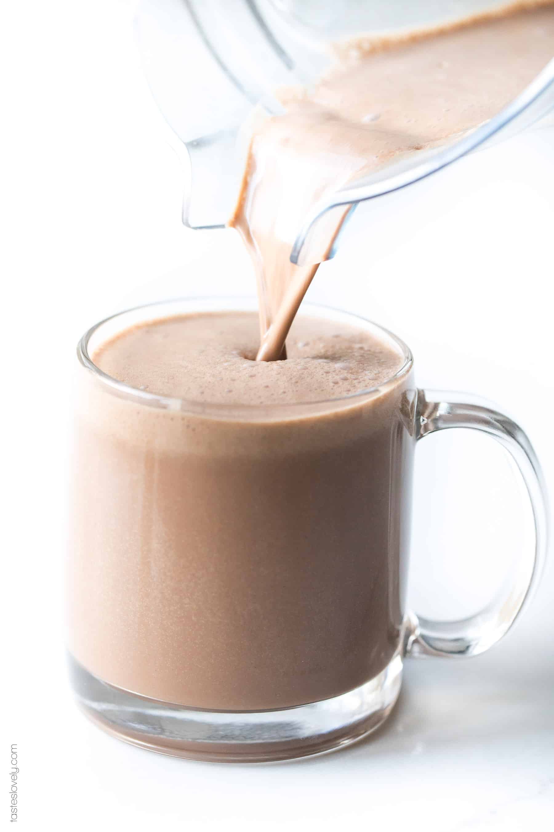 pouring hot chocolate into a clear mug