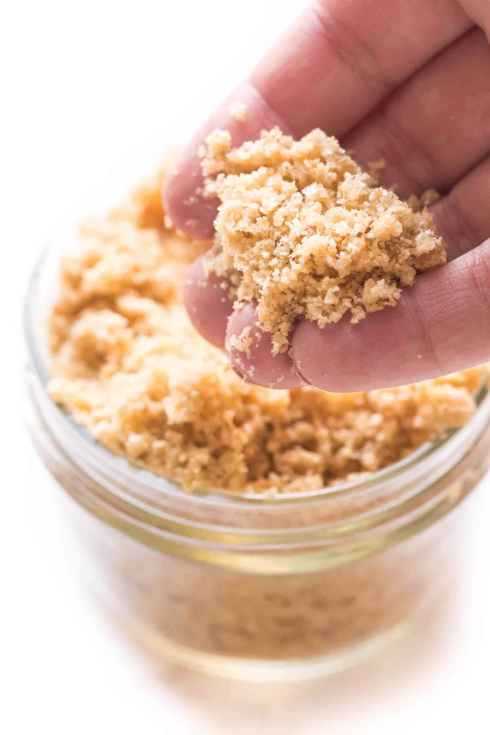 a closeup shot of pork panko in a hand above a mason jar