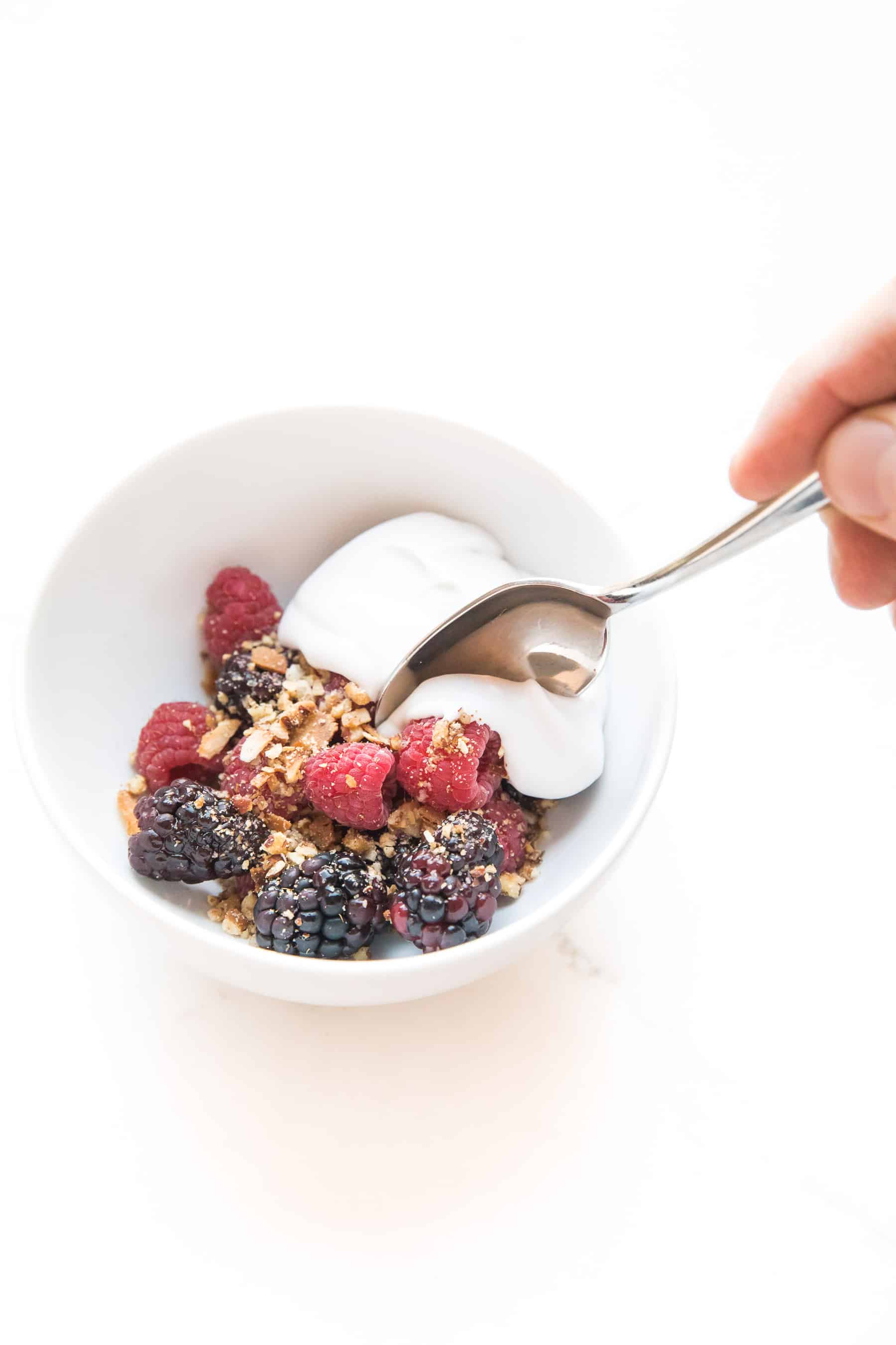 whole30 + keto raw berry crisp: raspberries + blackberries topped with pecan + shredded coconut with coconut whipped cream