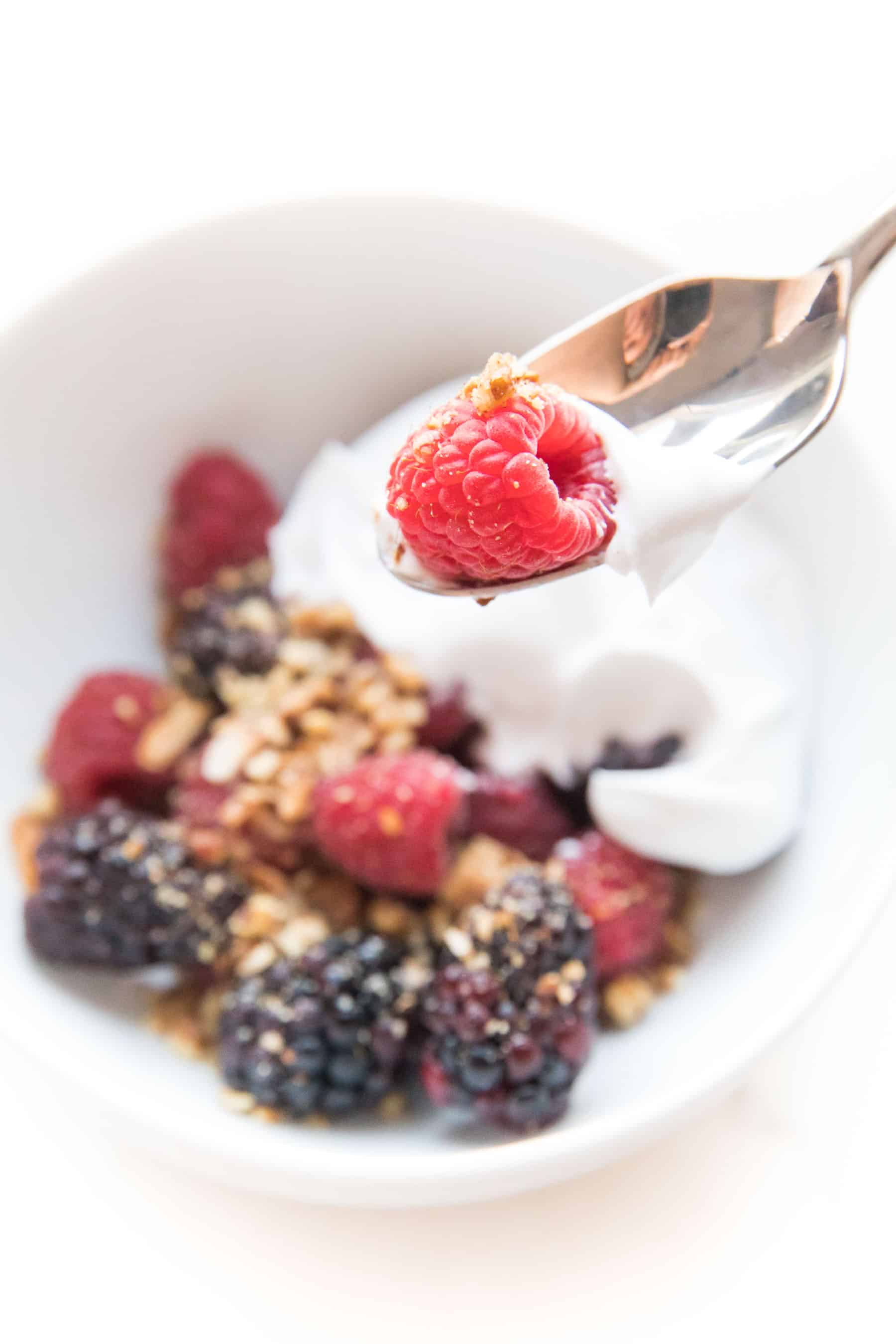 whole30 + keto raw berry crisp: raspberries + blackberries topped with pecan + shredded coconut with coconut whipped cream