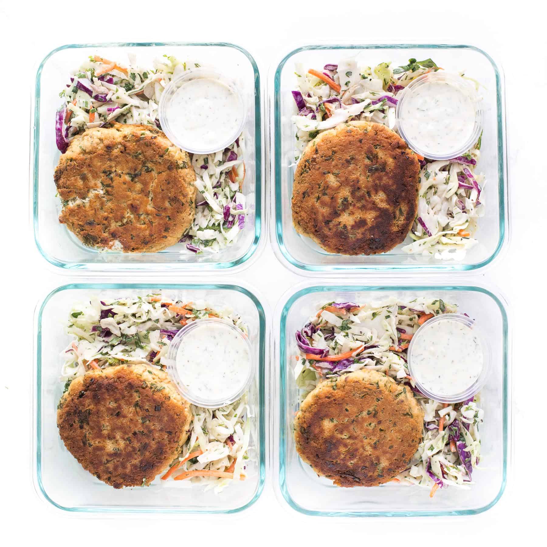 Meal prep of salmon cakes with coleslaw and aioli